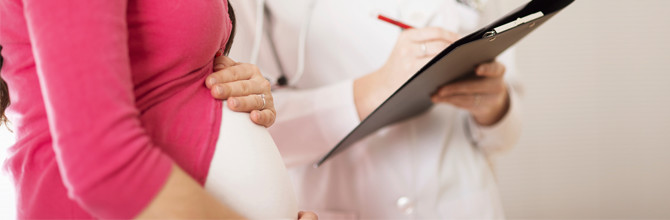 pregnant woman and physicians clipboard